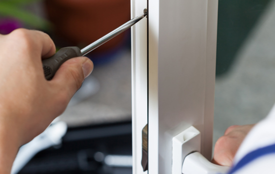 Handyman repairing window with screwdriver